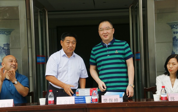 新乡市牧野区税务局党委书记、局长樊保峰向乐鱼官方在线入口党委书记张会民赠送税法知识书籍.jpg